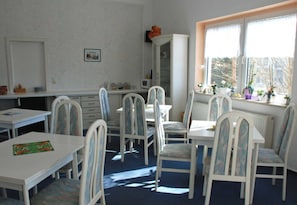 A room with white furniture, a window with plants, and a radiator.
