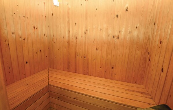 A wooden sauna with benches arranged in a corner.