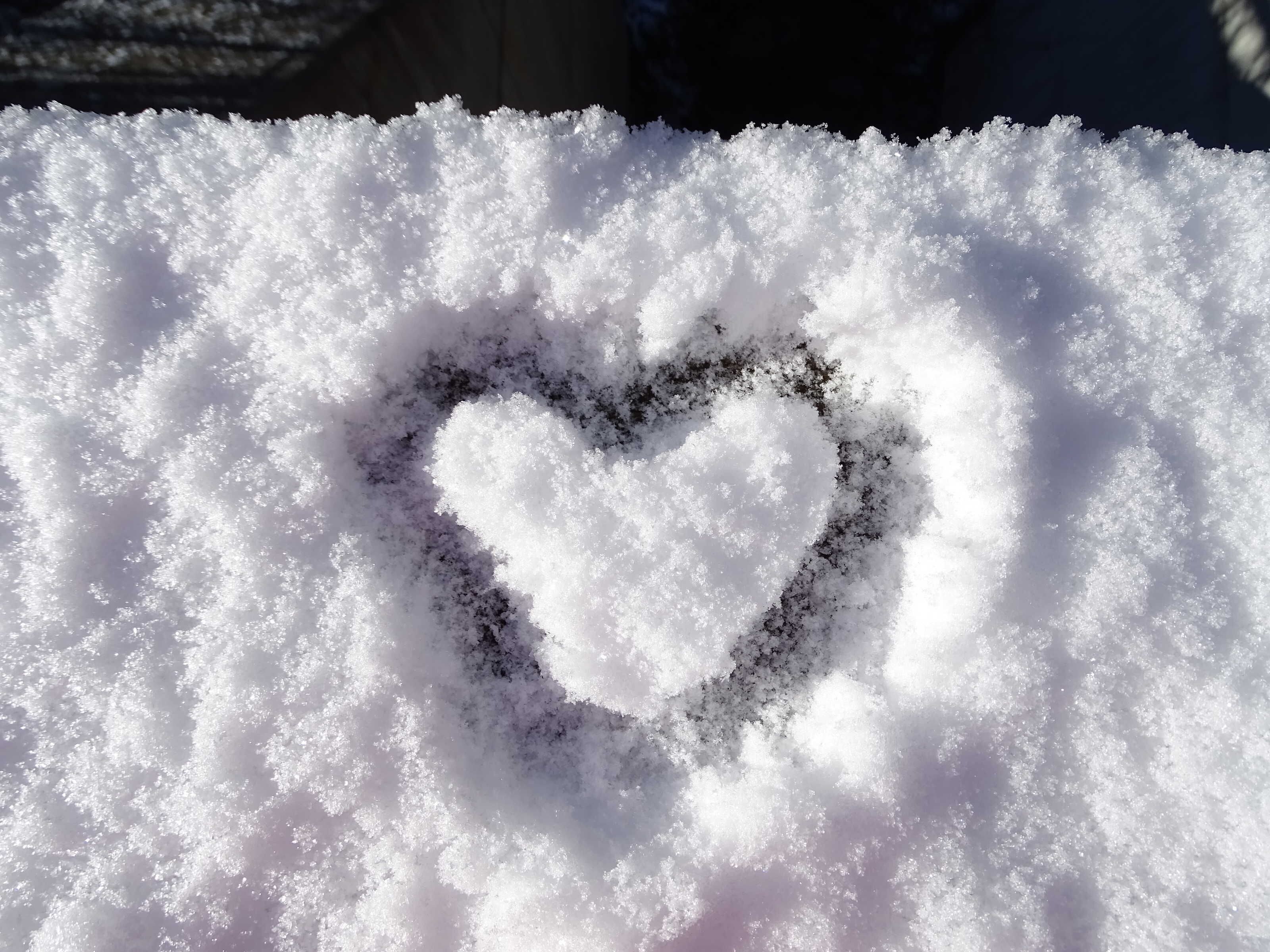 A heart-shaped snow design on a snow-covered surface.