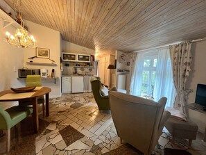 A compact living space with a kitchen, dining area, and seating. - Midsummer Night's Dream - Kunsthof Salsitz (Lohme auf Rügen)