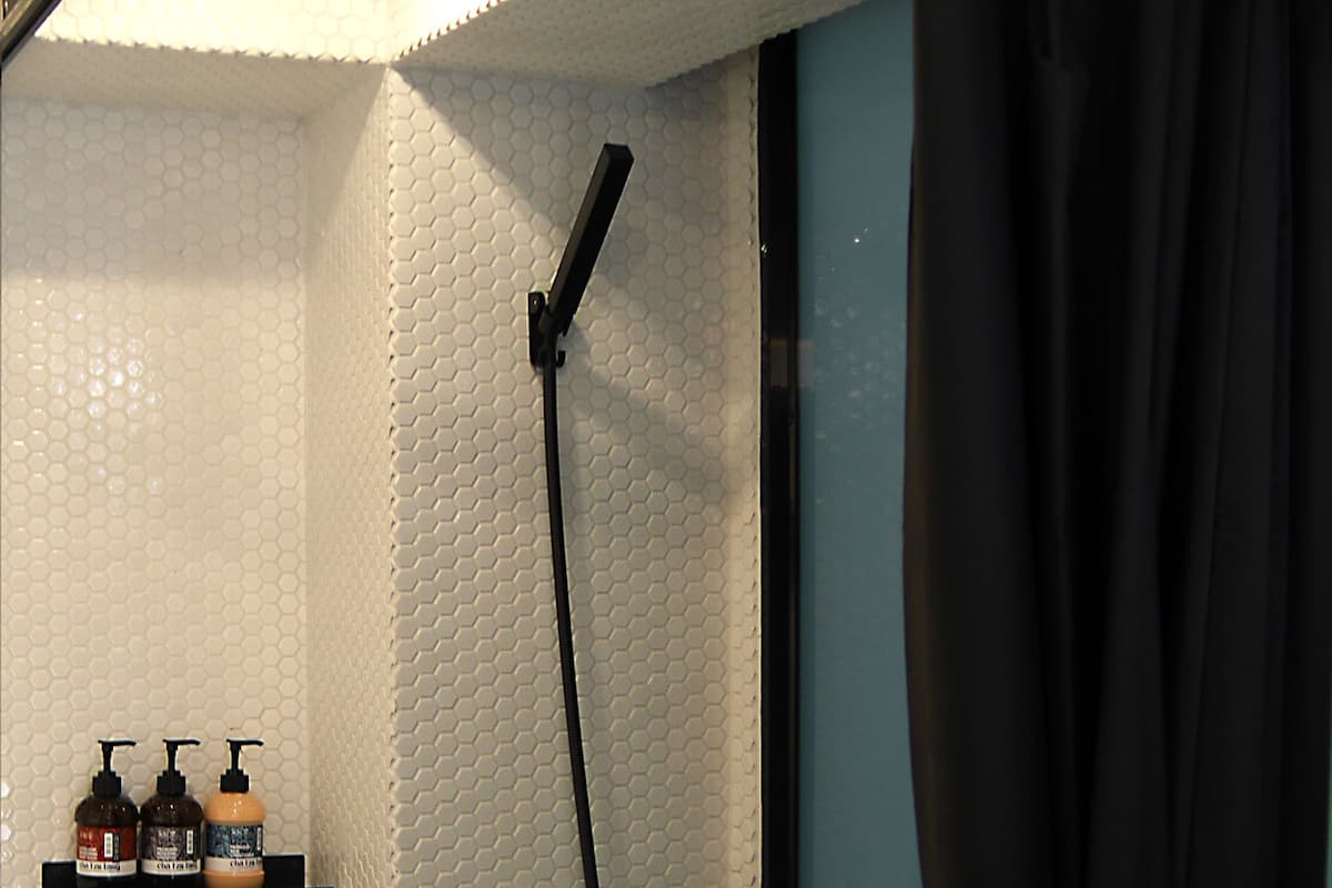Ein Badezimmer mit Dusche, Waschbecken und Ablage für Toilettenartikel.