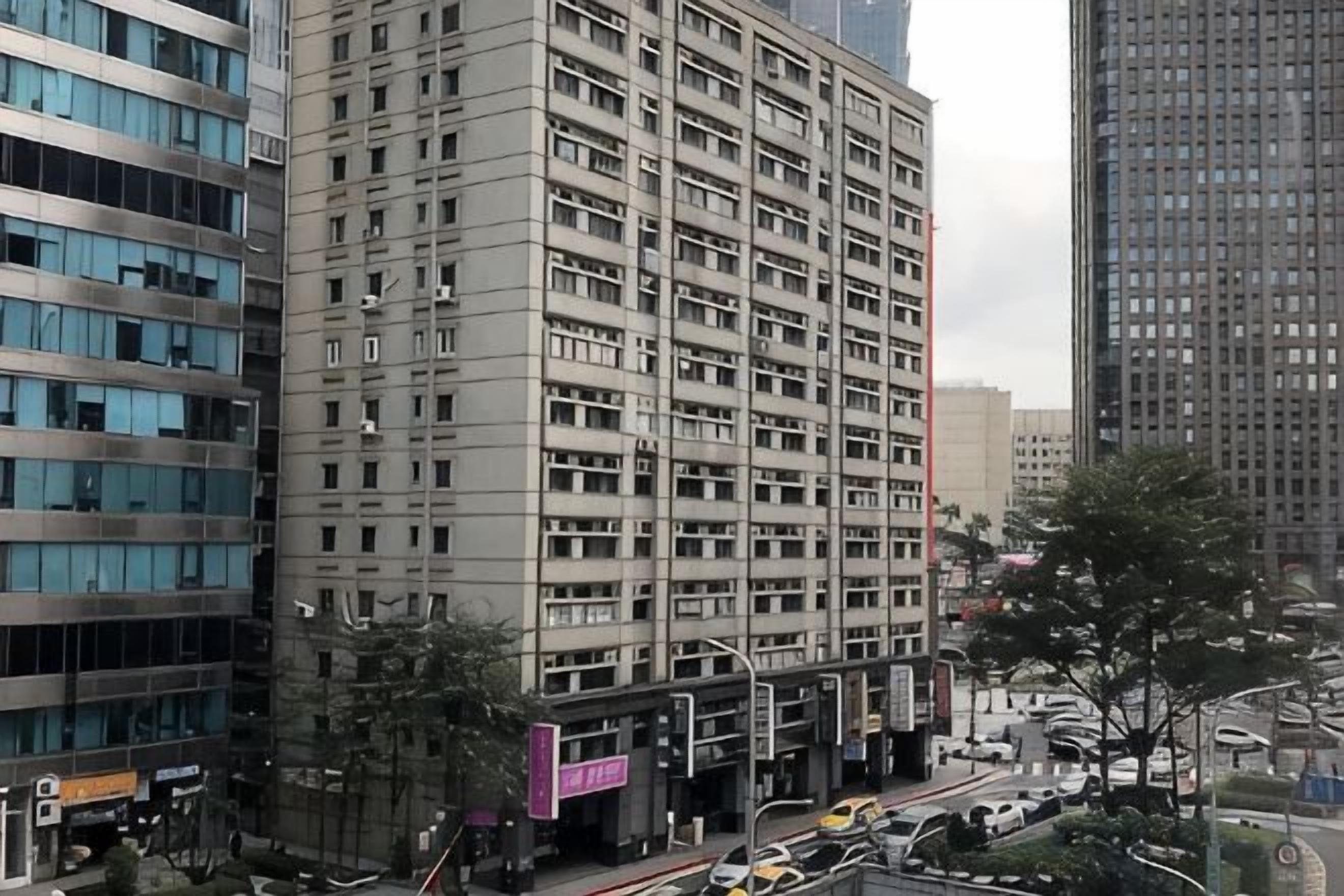 A multi-story building with a modern architectural design, featuring a series of balconies and a ground-level entrance.