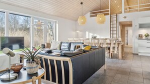 A modern living room with a sofa, dining area, and kitchen. - Gorgeous home in Vejby with sauna (Vejby)