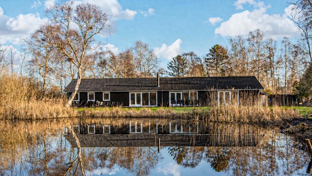 A house with a reflective pond in front, surrounded by trees. - Gorgeous home in Vejby with sauna (Vejby)