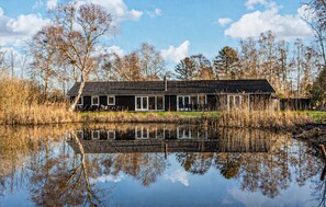 A house with a reflective pond in front, surrounded by trees. - Gorgeous home in Vejby with sauna (Vejby)