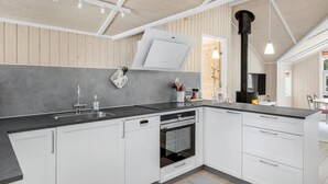 A modern kitchen with white cabinets, a built-in oven, and a black stove. - Beautiful home in Nexø with WiFi (Nexø)