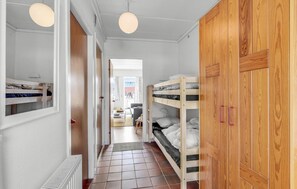 Cozy bedroom area with two bunk beds and a wardrobe, offering a comfortable retreat.