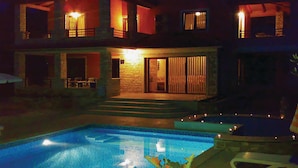 A nighttime view of a two-story house with a swimming pool. - Cozy home in Buje with private swimming pool, can be inside or outside (Buje)