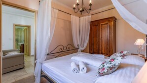 Une chambre à coucher bien rangée, avec un lit, une armoire en bois, une table de chevet avec une lampe et une chaise.