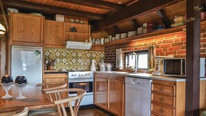 A kitchen with wooden cabinets, a stove, a dishwasher, and a microwave. - 3 bedroom amazing home in Hvide Sande (Hvide Sande)