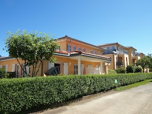 En række huse i middelhavsstil med en belagt indkørsel og velplejede hække.