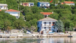 A coastal house with a balcony, surrounded by trees and a stone wall. - Pet friendly home in Baric Draga with WiFi (Baric Draga)