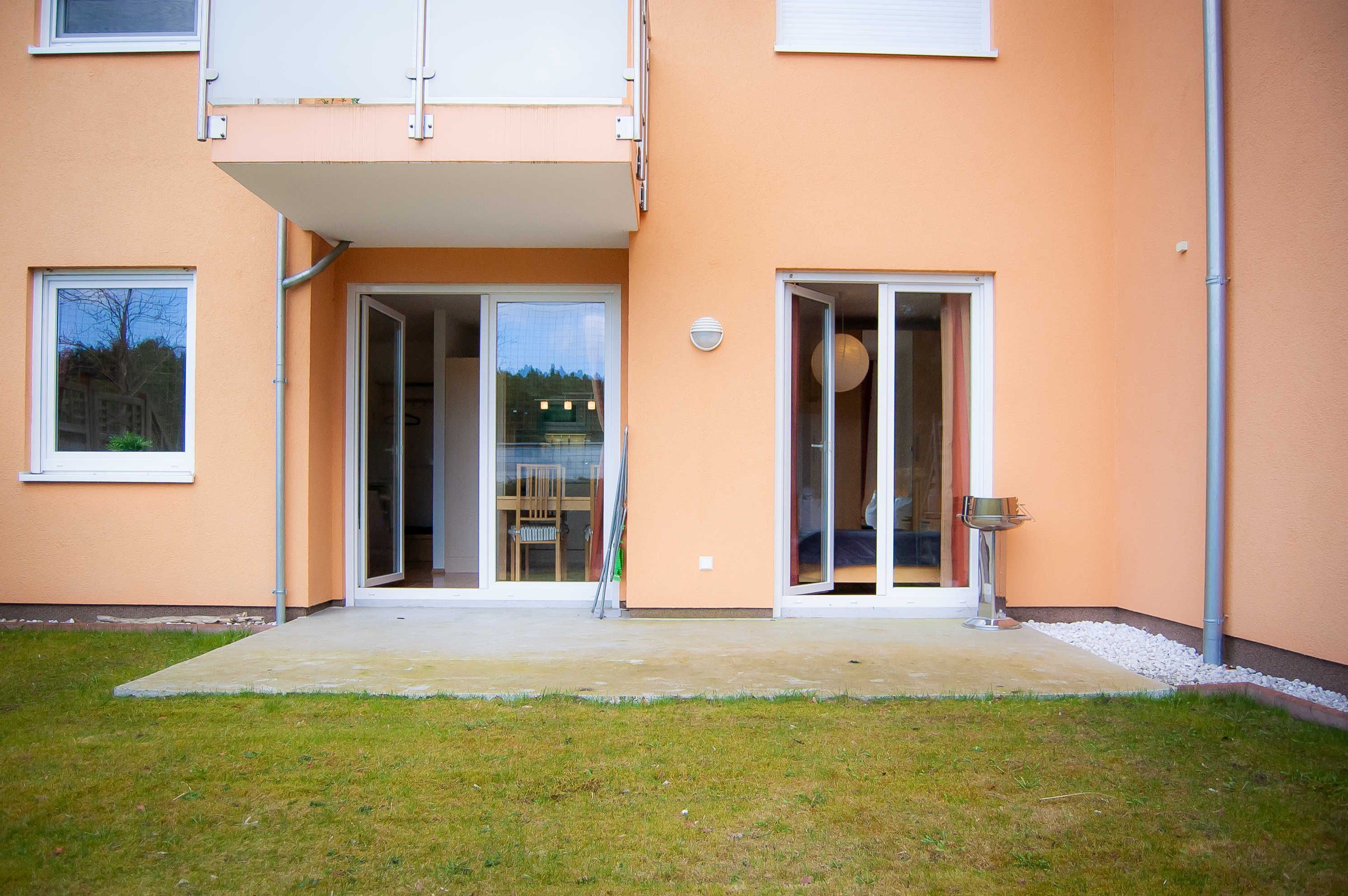 Ein zweistöckiges Gebäude mit flachem Dach, großen Schiebegläsern und einem kleinen Balkon.