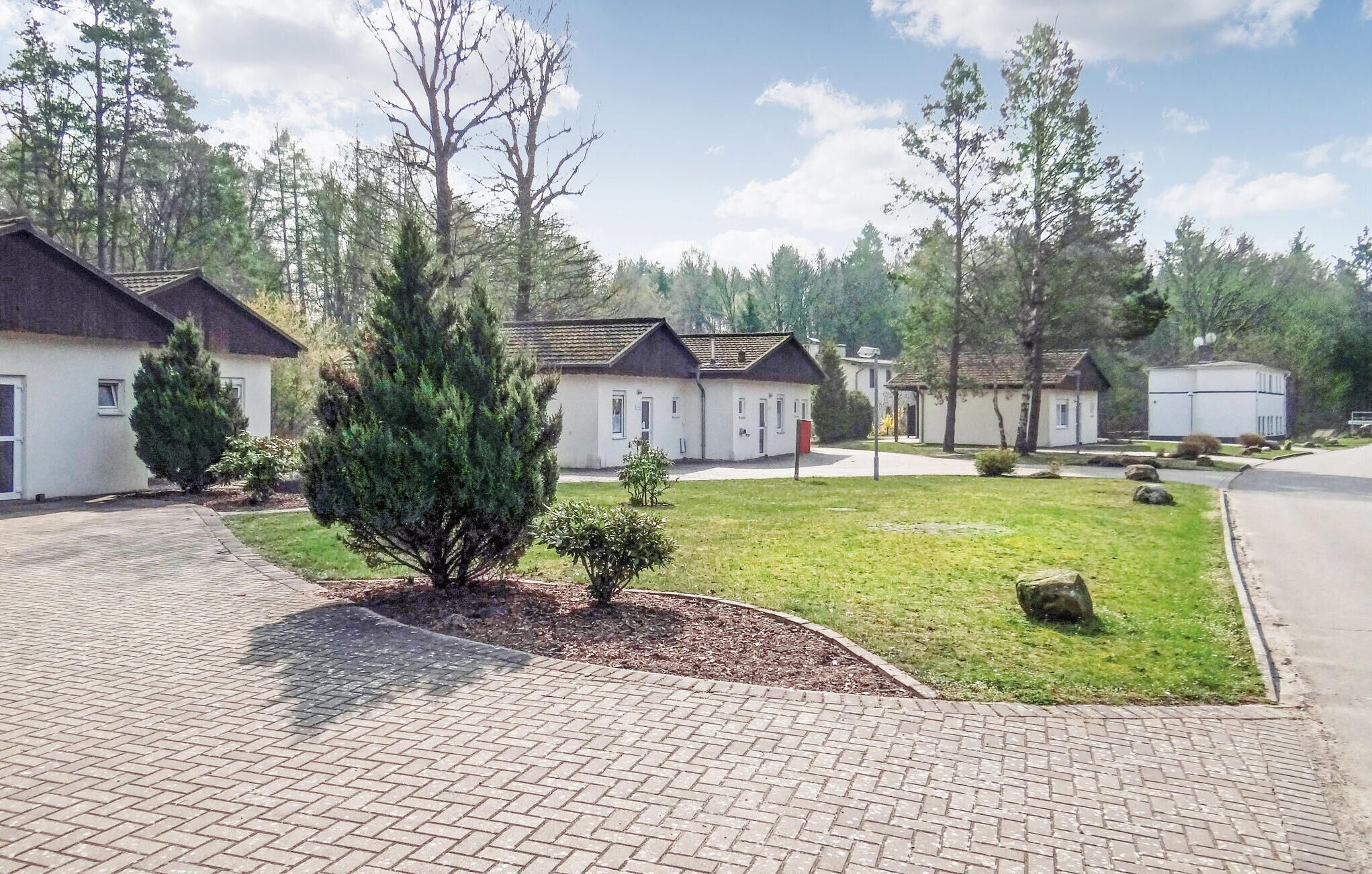Un quartier résidentiel composé de maisons individuelles, doté d’une allée pavée et d’une pelouse bien entretenue.