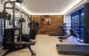 A gym with cardio equipment, weight machines, and a treadmill.