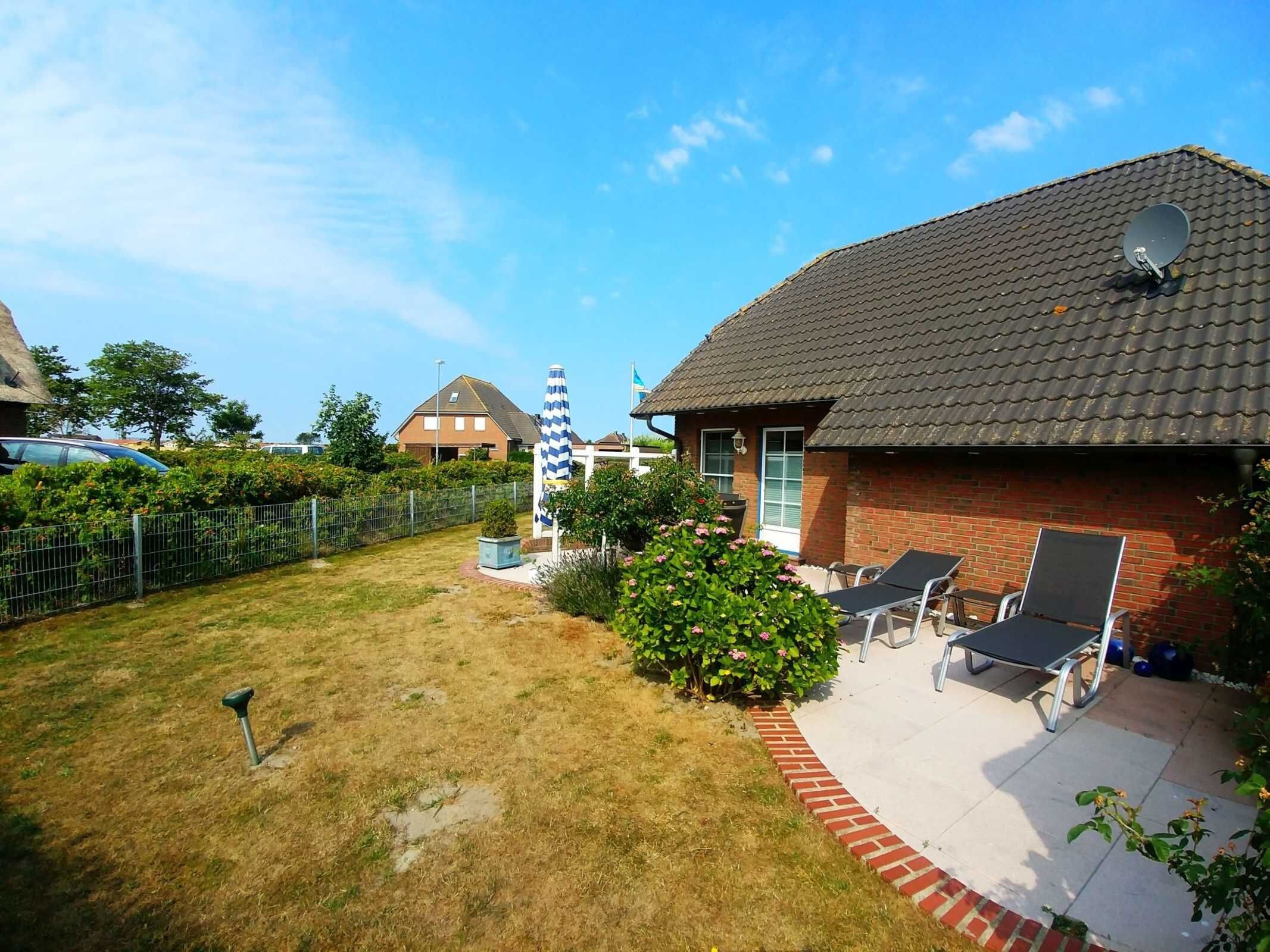 A backyard with a lawn, a satellite dish, and a brick house with a tiled roof.