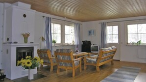 Ein Wohnzimmer mit Holzmöbeln, einem Kamin und großen Fenstern.