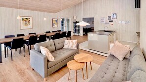 Un salon moderne comprenant un canapé, une table basse, un coin repas et une cuisine.