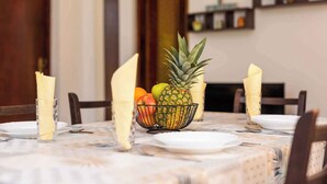 Tavola imbandita con piatti, una ciotola di frutta e tovaglioli.