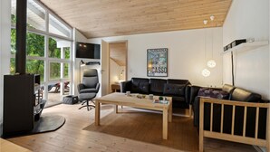 Una sala de estar moderna con chimenea, un sofá, una mesa de centro y un televisor.