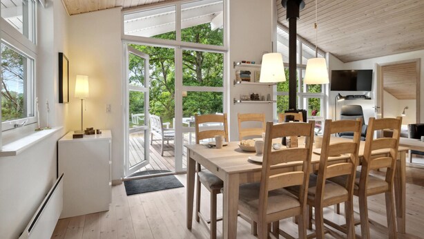 Una cocina moderna con comedor, ventanas amplias y televisor en la sala de estar.