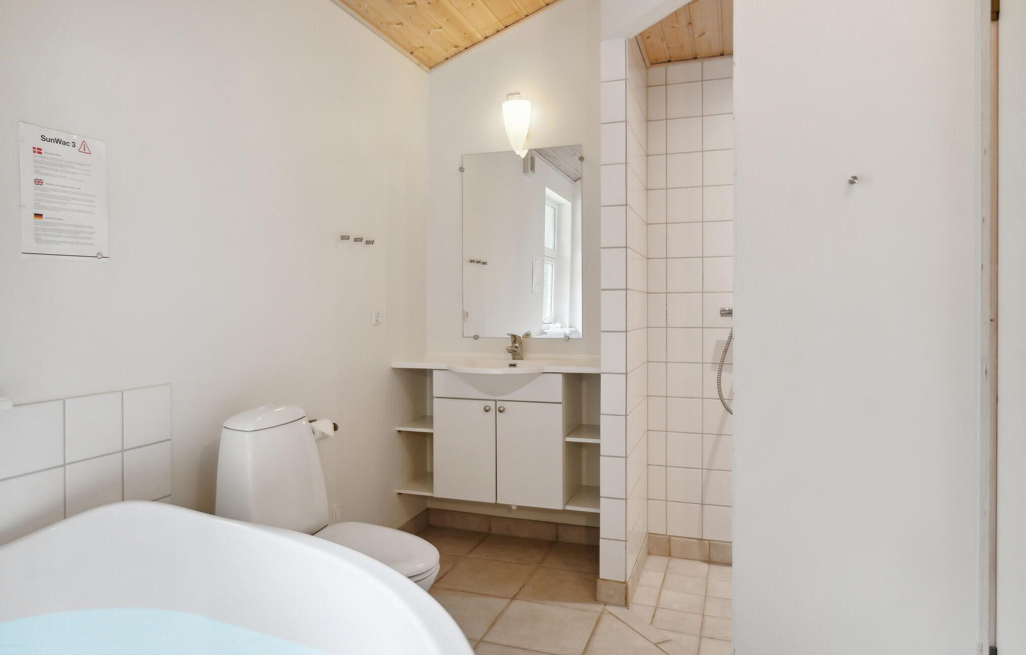 A bathroom with a toilet, sink, and shower area.