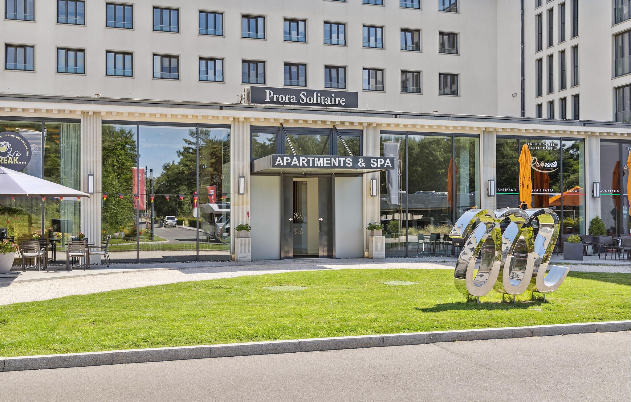 Ein Gebäude mit einem Schild für "Prora Solitaire Apartments & Spa" und einer Glasfassade.