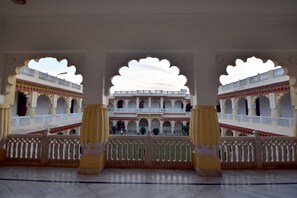 Un imposant édifice d’architecture remarquable, doté de nombreux balcons et d’arcades, avec des garde-corps finement ouvragés et un sol en marbre.