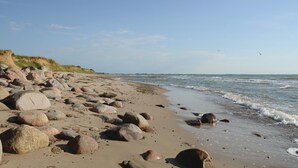 Una playa rocosa con grandes rocas y cielo despejado.