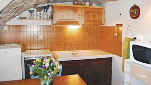 A compact kitchen with wooden cabinets, a white sink, and a microwave. - 1 bedroom nice apartment in La Beaume (La Beaume)