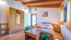 A bedroom with a wooden bed, bedside tables, a desk, and a wardrobe. - Beautiful home in Rovinj (Rovinj)