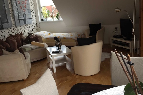Wohnzimmer mit Couch,Sitzgruppe mit 4 Stühlen und einem Einzelbett