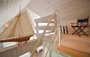 A sailboat in a wooden interior with a ladder, a director's chair, and a striped bag. - Stunning home in Rømø with sauna (Rømø)