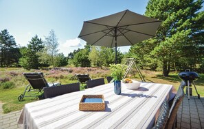 Enjoy al fresco dining in a serene garden setting, complete with a grill and comfortable seating for two.