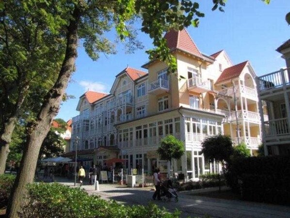 A multi-story hotel with a classic European architectural style, featuring balconies and a central courtyard.