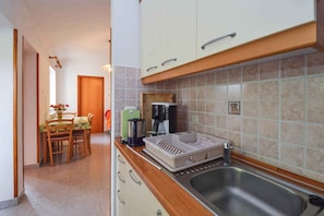 A compact kitchen with a sink, a coffee maker, and a toaster. - Holiday apartment 100 m from the beach (Banjole)