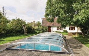 Relax by the sleek, contemporary pool surrounded by lush greenery and a simple, functional building.