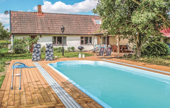 Enjoy a refreshing swim in the pool surrounded by a deck with lounge chairs and a barbecue grill.