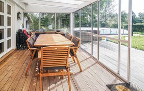 Relax in this serene room with a large table and comfortable seating, surrounded by lush views and natural light.