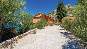 A gravel path leading to a building with a sloped roof and satellite dish.