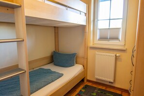 A bunk bed room with a window and radiator. - Apartment 1 - Apartments in Blu Hus (Kröslin)