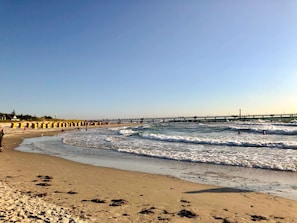 A beach with waves, a pier, and a lighthouse in the distance. - Vacation apartment Alfredo (Wustrow)