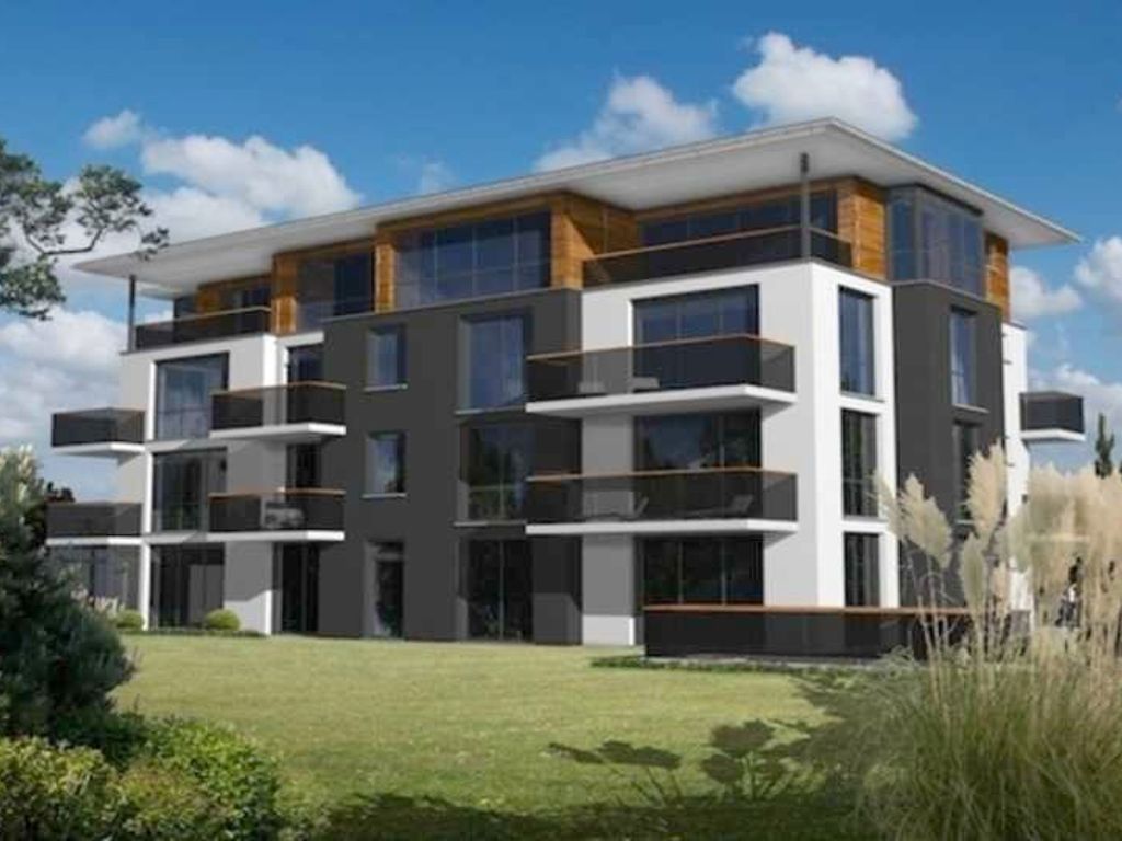 Un immeuble moderne à plusieurs étages, doté de balcons, de grandes fenêtres et d’un toit plat.