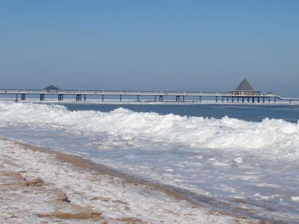 A pier extending into the water with a building at the end.
