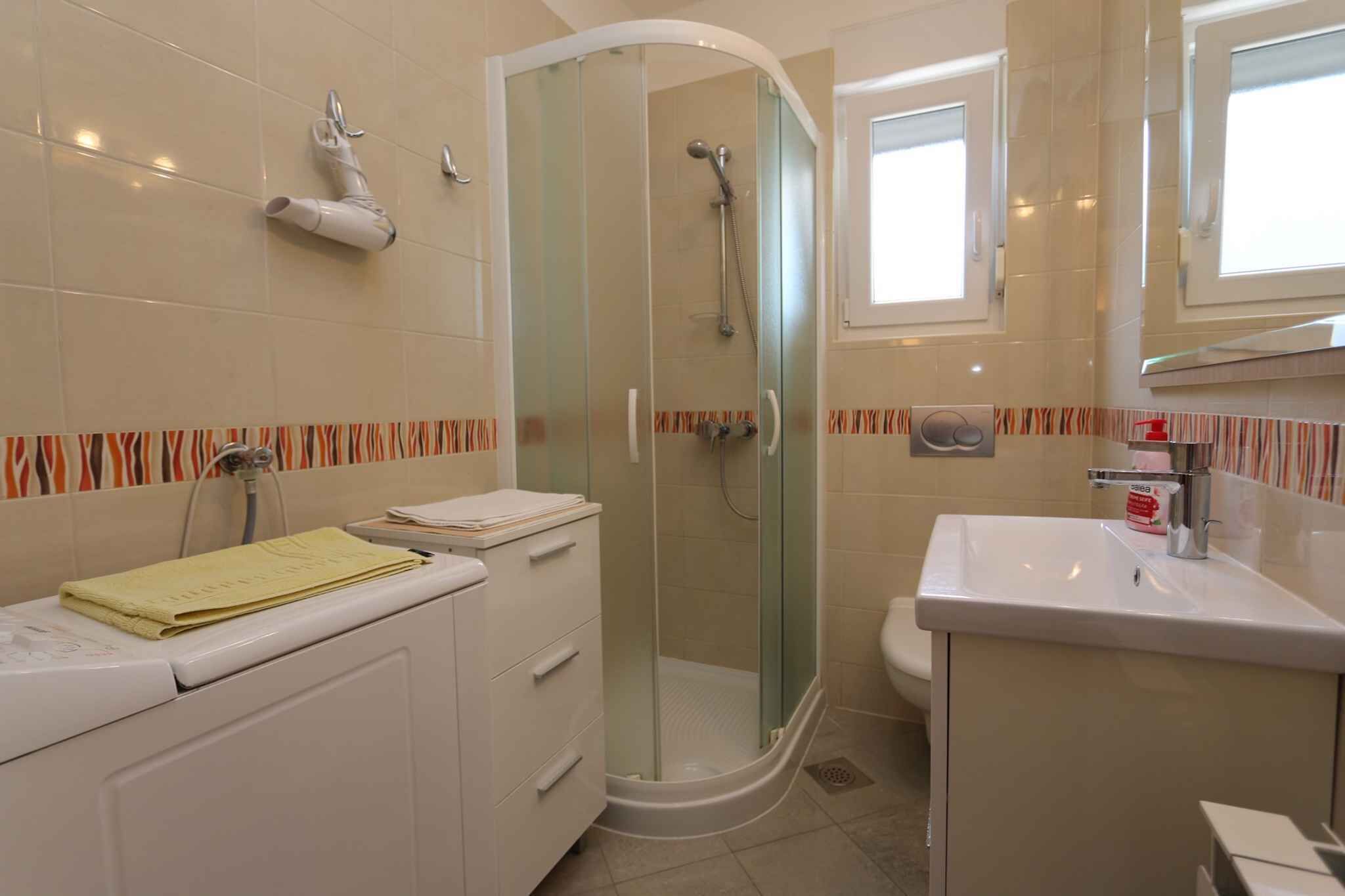 Un bany amb dutxa de vidre, un lavabo i un vàter.