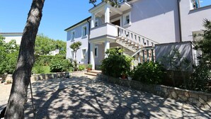 A two-story building with a stone staircase leading to a balcony. - Holiday apartment with balcony and sea view (Šilo)