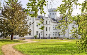 Un grand bâtiment historique doté d’une tour imposante et de fenêtres en arc de cercle.
