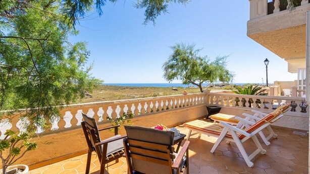 A terrace with a view of the sea, furnished with wooden chairs and a table, and a potted plant. - Cala Morlanda Palma d Mallorca (Cala Morlanda)
