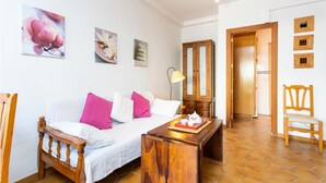 A cozy room with a bed, a wooden chair, a small table with a tray, and a mirror. - Cala Morlanda Palma d Mallorca (Cala Morlanda)