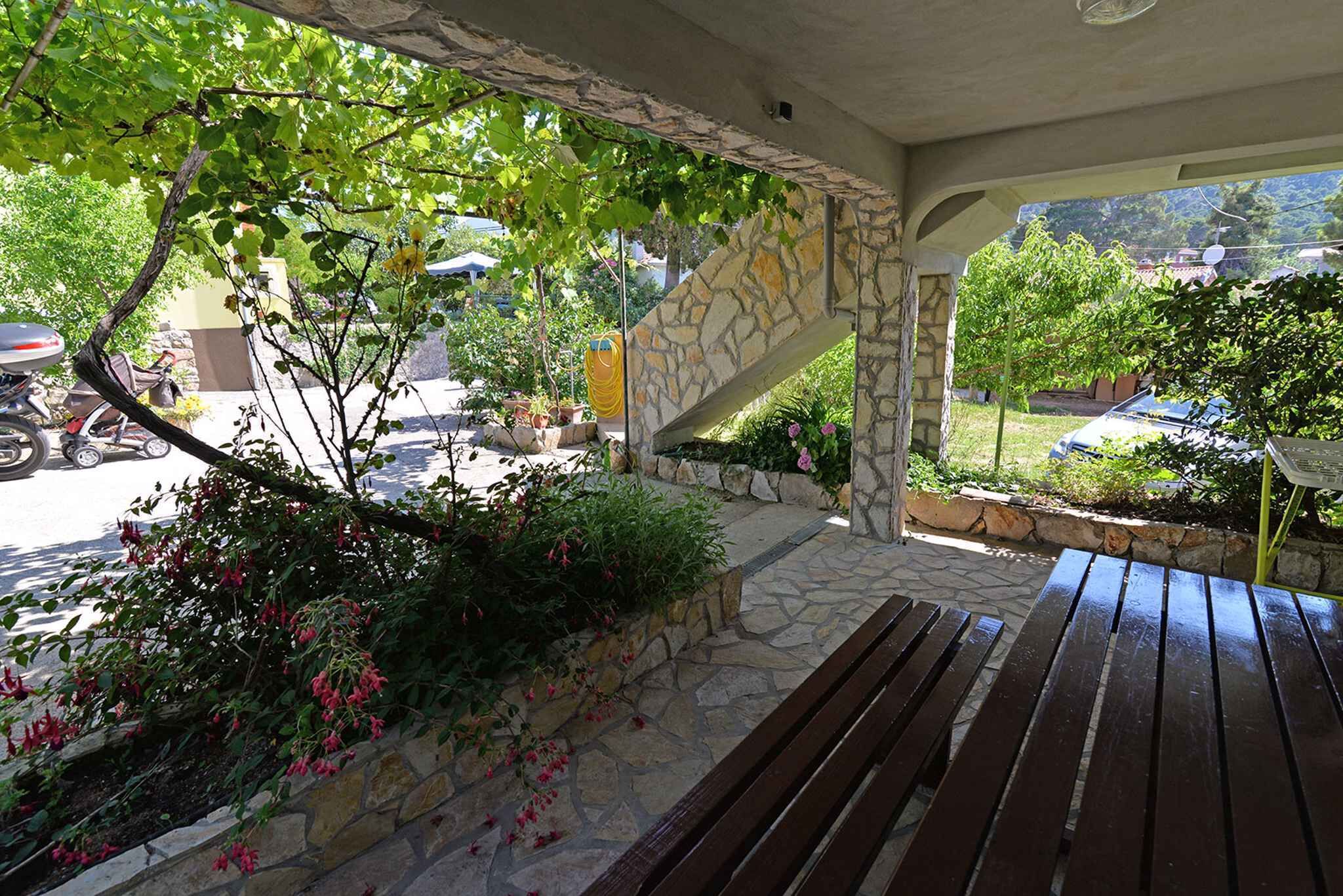 Un espace extérieur abrité, doté de murs en pierre et d’un banc en bois.